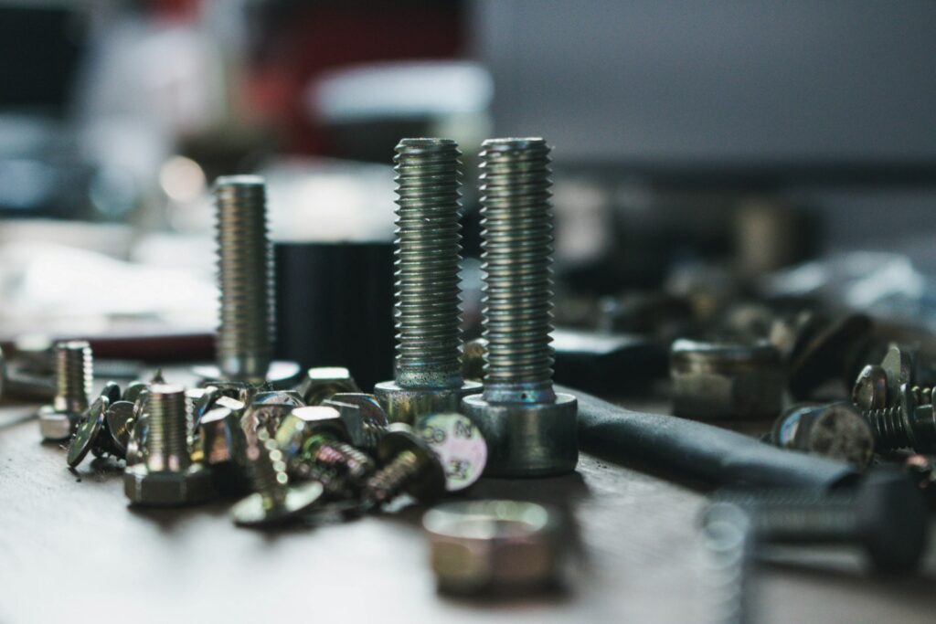 Pile of grey stainless steel bolts and screws, the kind of parts needing a coating